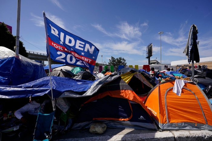 Nightly 4-13-21 photo A campaign flag for President Joe Biden flies over tents at a makeshift camp of migrants at the border port of entry leading to the United States in Tijuana, Mexico.