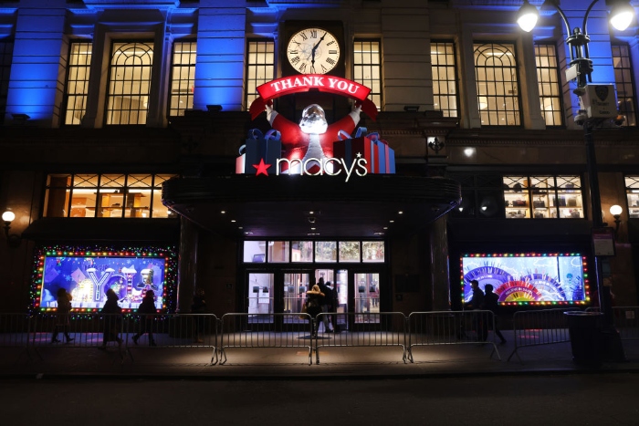 People look at the newly revealed Macy's Herald Square holiday windows in New York City. This year's windows look to give thanks to the city and those who worked on the frontlines of the pandemic, including first responders and essential workers.
