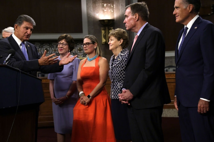 Nightly 8-23-21 photo (L-R) Sen. Joe Manchin (D-W.Va.) speaks as Susan Collins (R-Maine), Kyrsten Sinema (D-Ariz.), Jeanne Shaheen (D-N.H.), Mark Warner (D-Va.) and Mitt Romney (R-Utah) listen during a news conference after a procedural vote for the bipartisan infrastructure framework at Dirksen Senate Office Building on Capitol Hill.