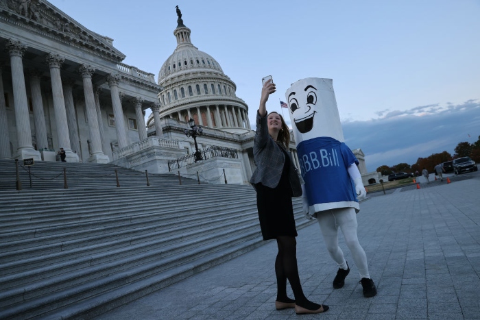 Nightly 11-18-21 photo 3 Dressed in a costume depicting the Build Back Better bill, Bob Hayes of the National Domestic Workers Alliance poses for photos with congressional staffers on Capitol Hill.