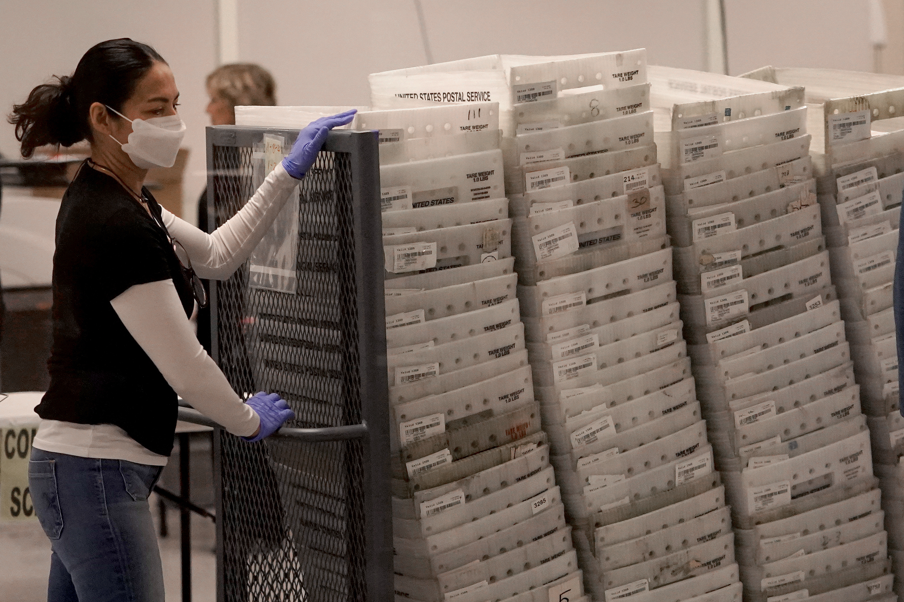 An election worker arrives with ballots to be tabulated inside the Maricopa County Recorder's Office today in Phoenix.