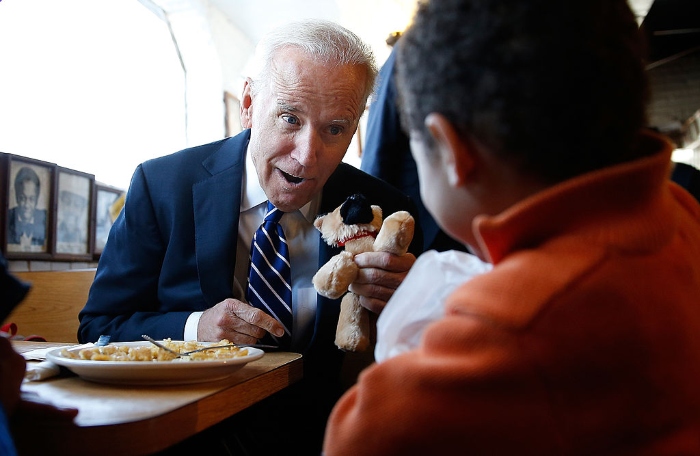 Then-Vice President Joe Biden gives a young boy a stuffed version of Biden's dog, Champ, while visiting a diner on March 26, 2014, in Washington. 