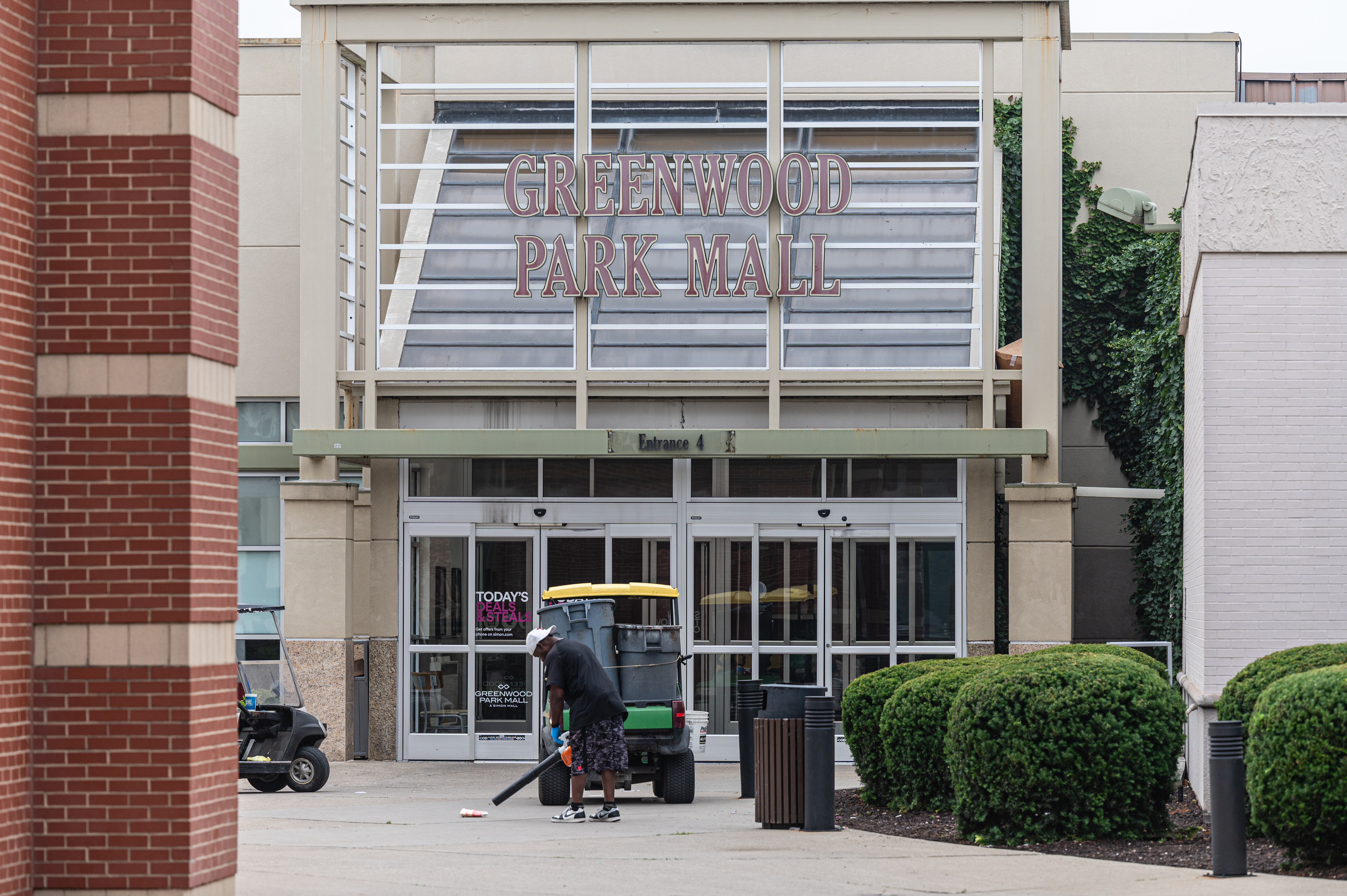 A worker cleans up outside the Greenwood Park Mall