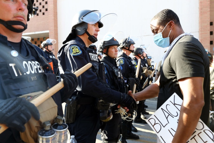 A demonstrator shakes hands with a police officer during a protest Sunday in Kansas City, Mo. 