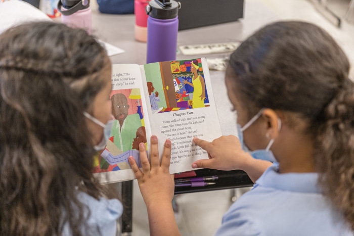 Nightly 2-1-22 photo Two girls read a book together during a lesson at Carter Traditional Elementary School in Louisville, Ky.