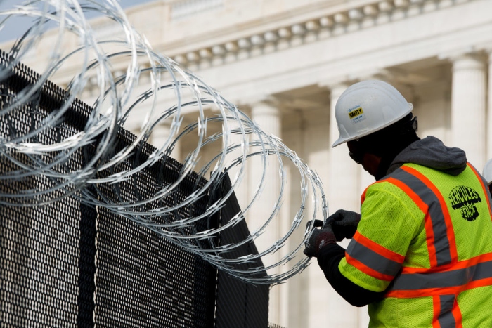 Work crews install razor wire on top of the fencing surrounding the U.S. Capitol ahead of the inauguration in Washington. 