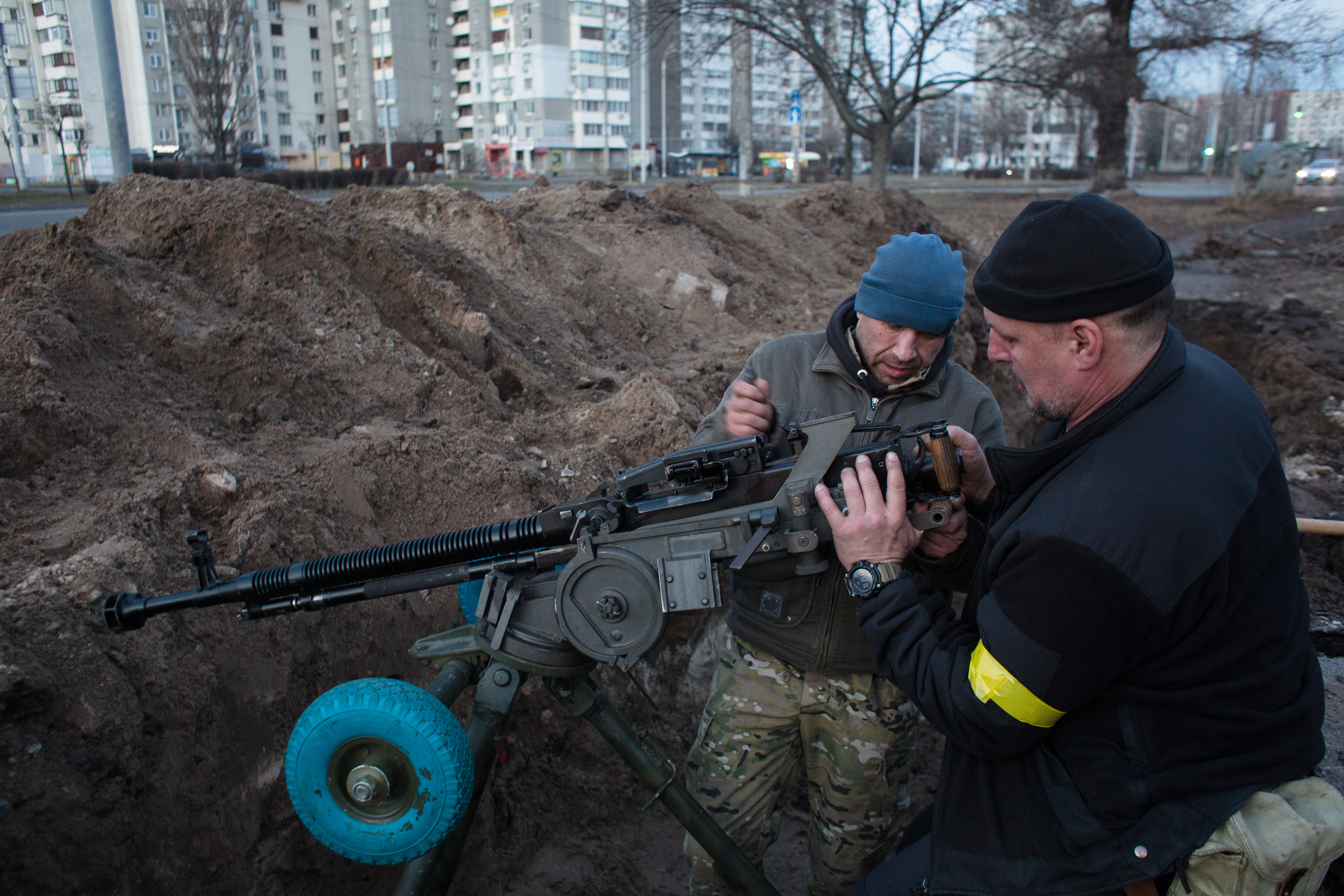 A photo of Ukranian volunteer soldiers loading a gun. 