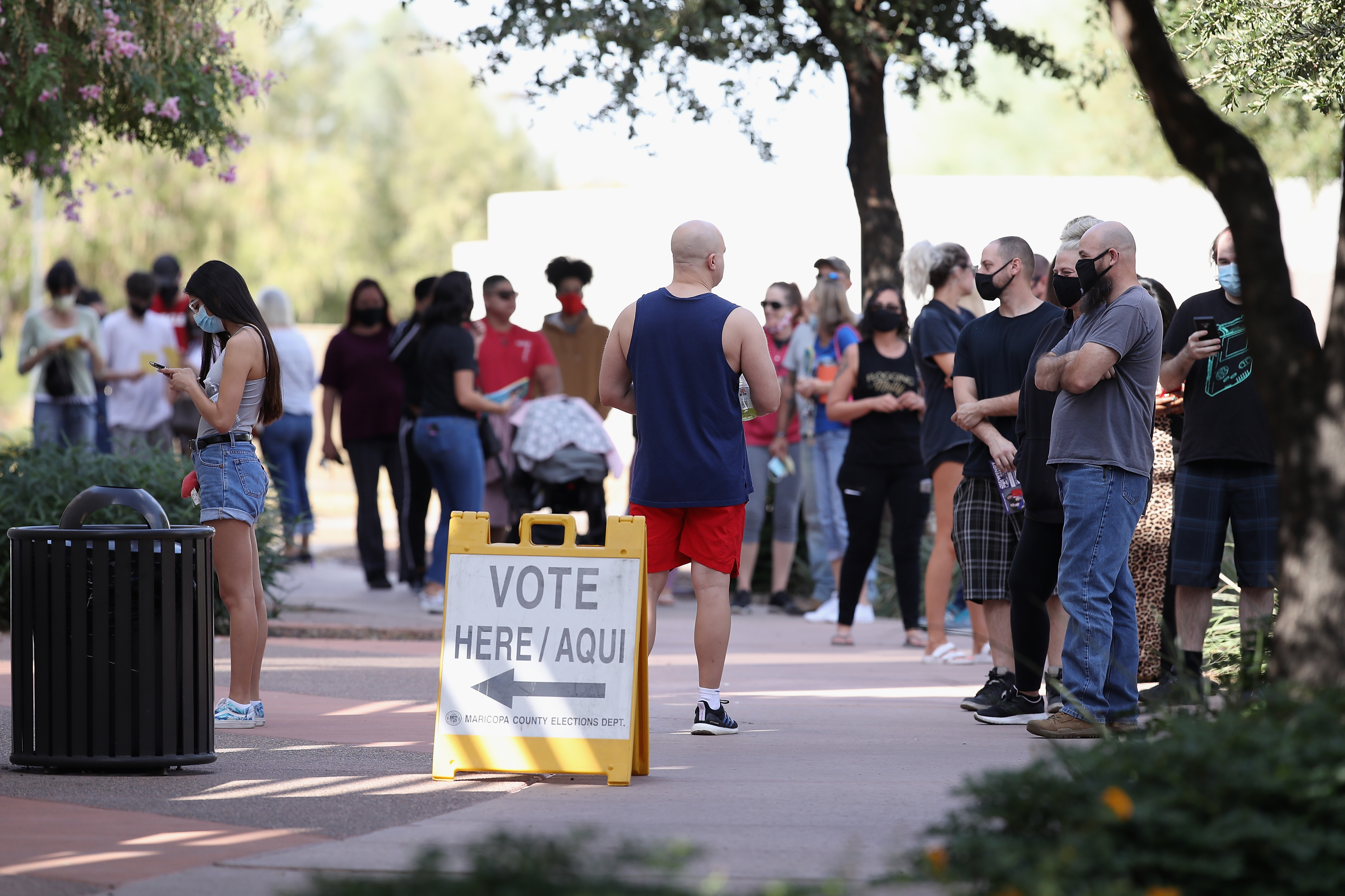 Voters wait in line at a polling location.