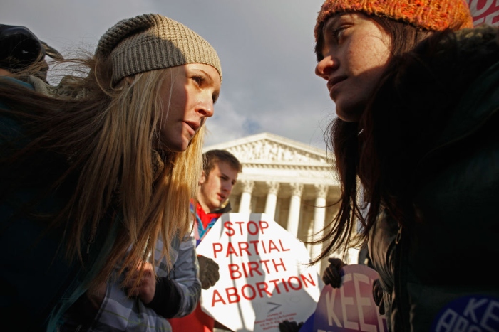 Anti-abortion demonstrators and abortion rights supporters argue in front of the Supreme Court.