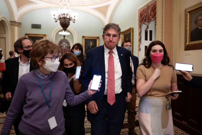 Nightly 12-20-21 photo Sen. Joe Manchin is followed by reporters as he leaves a caucus meeting with Senate Democrats at the U.S. Capitol Building.