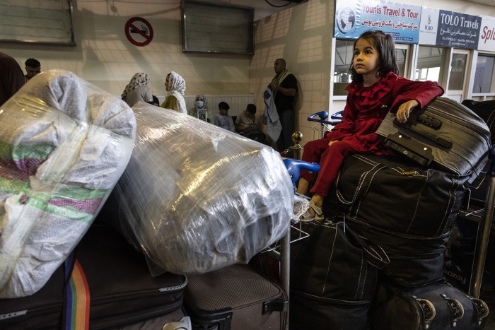 Nightly 8-17-21 photo 3 Safa, 5, sits on luggage as her family checks into their flight to Los Angeles at Hamid Karzai International Airport in Kabul.