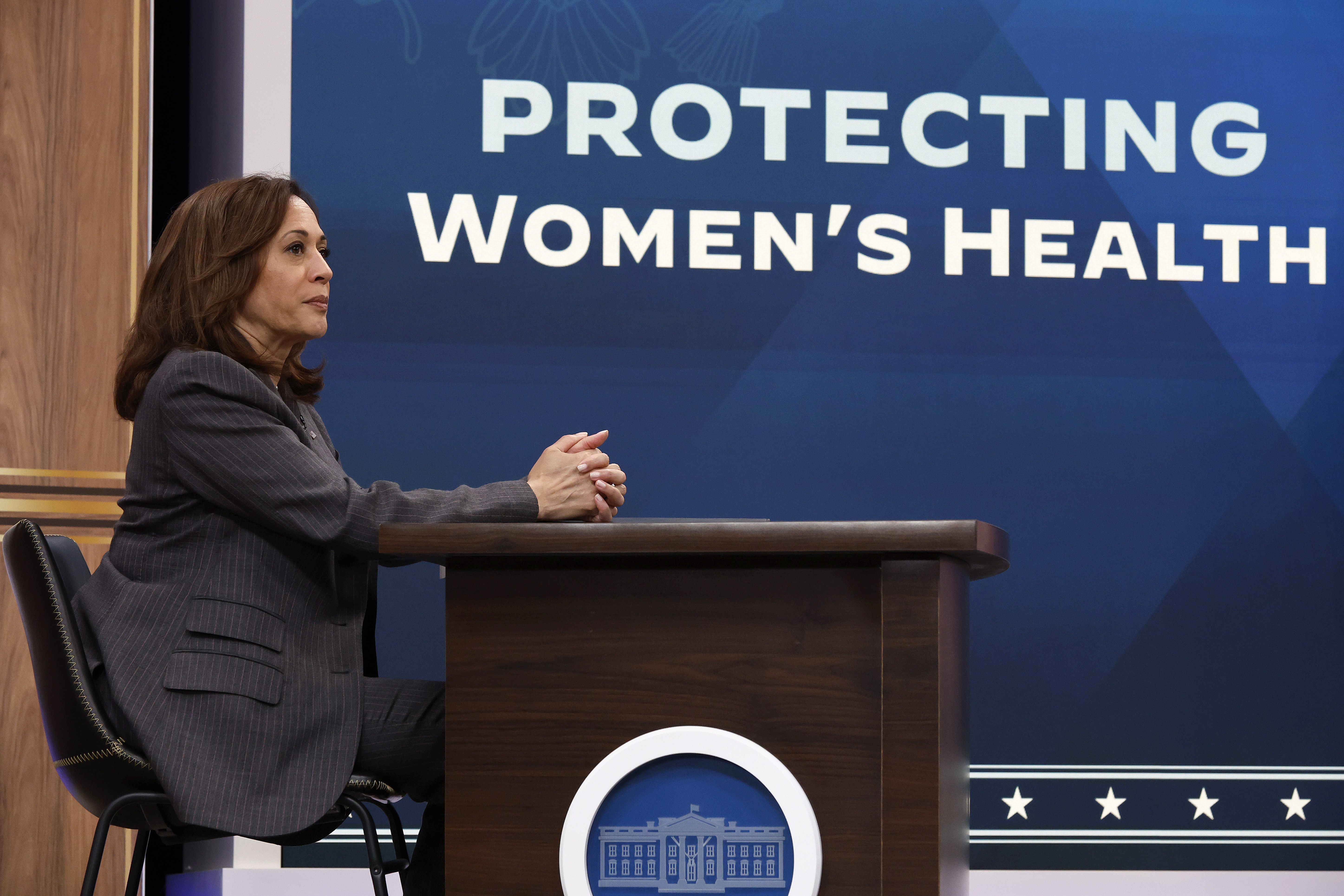 Kamala Harris delivers remarks in front of a sign that says PROTECTING WOMEN'S HEALTH