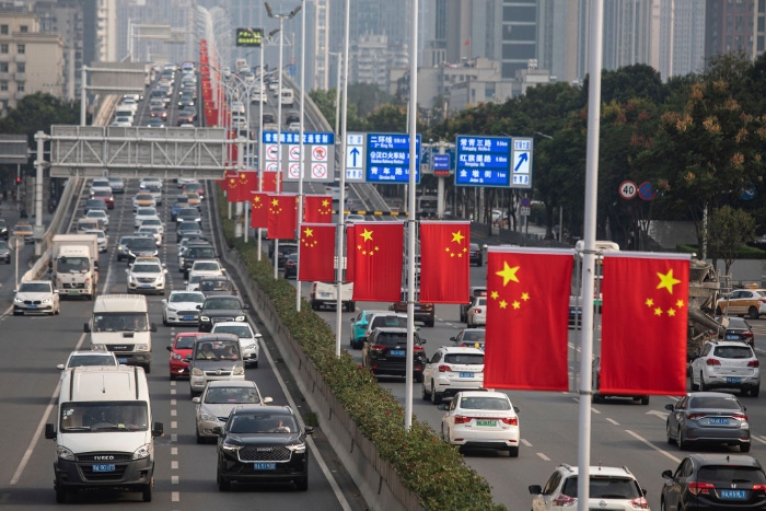 Nightly 9-28-21 photo Traffic passes through streets decorated with national flags in Wuhan, China.