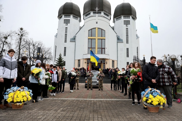 Mourners prepare to walk to the cemetery during the funeral for a Ukrainian soldier in Kamianka-Buzka, Ukraine.