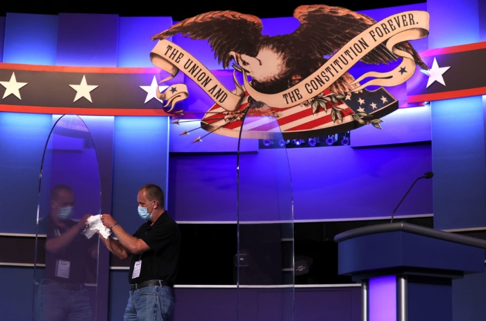 Nightly 10-22 photo A worker cleans newly installed plexiglass shields on the debate stage inside the Curb Event Center ahead of the presidential debate at Belmont University in Nashville.