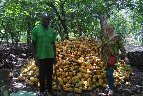 Frederick Gamor and Joanna Pollard with a pile of cocoa pods 