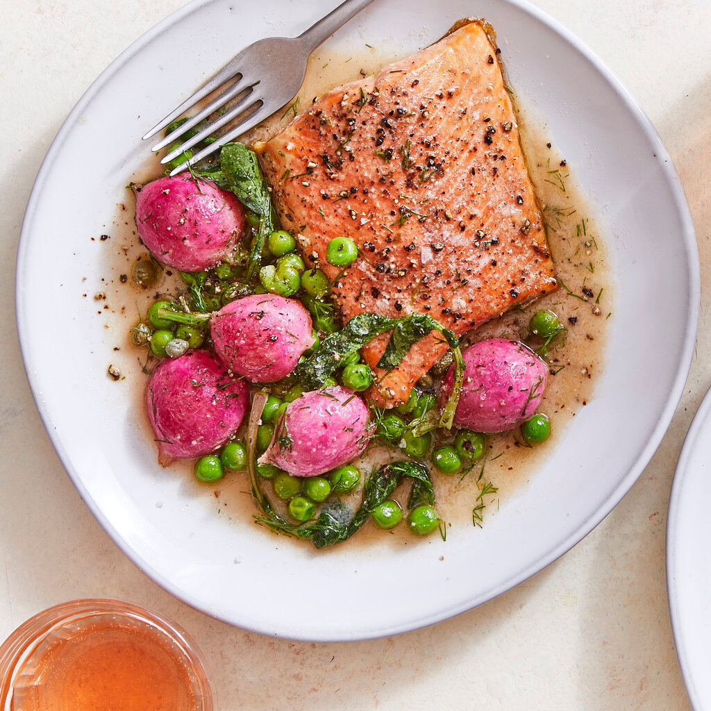 A plate of salmon with radishes and peas.