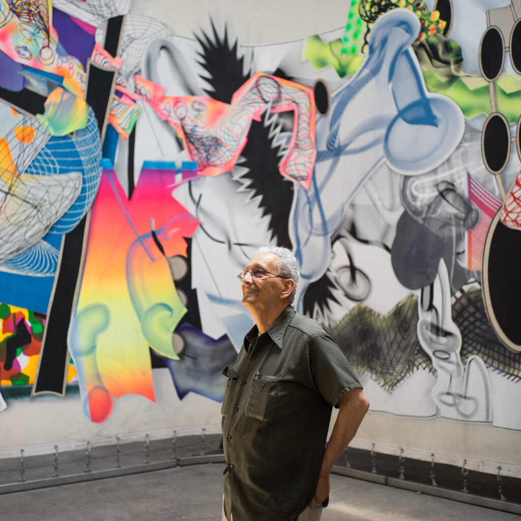 The artist Frank Stella looks up at a giant multicolored work of abstraction in 2015.