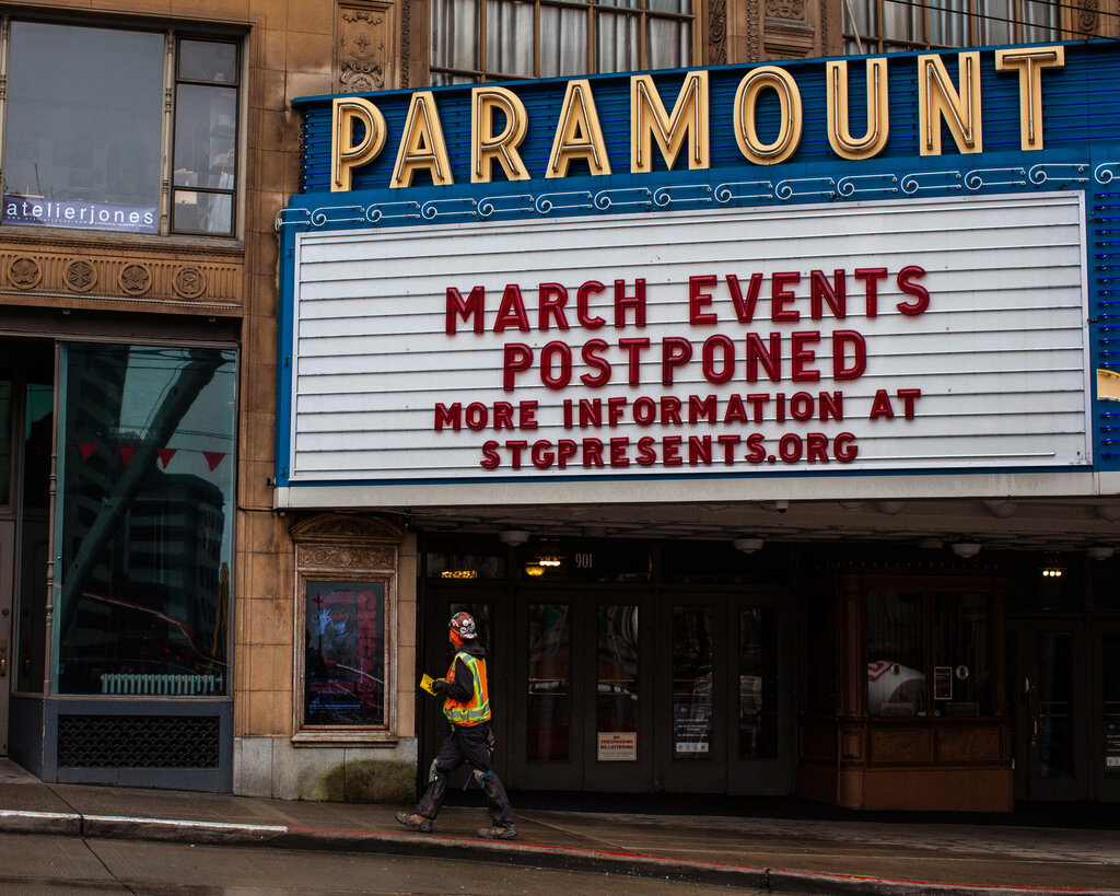 A movie theater marquee with a message that events in March are postponed.