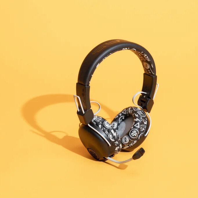 Over the ear headphones with a microphone attachment on a yellow background.