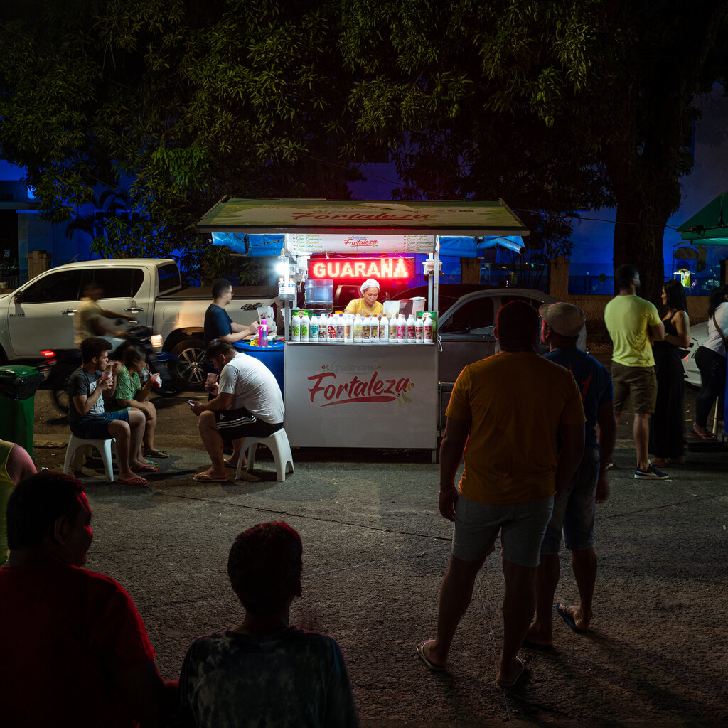 A park at night with small food trucks. 