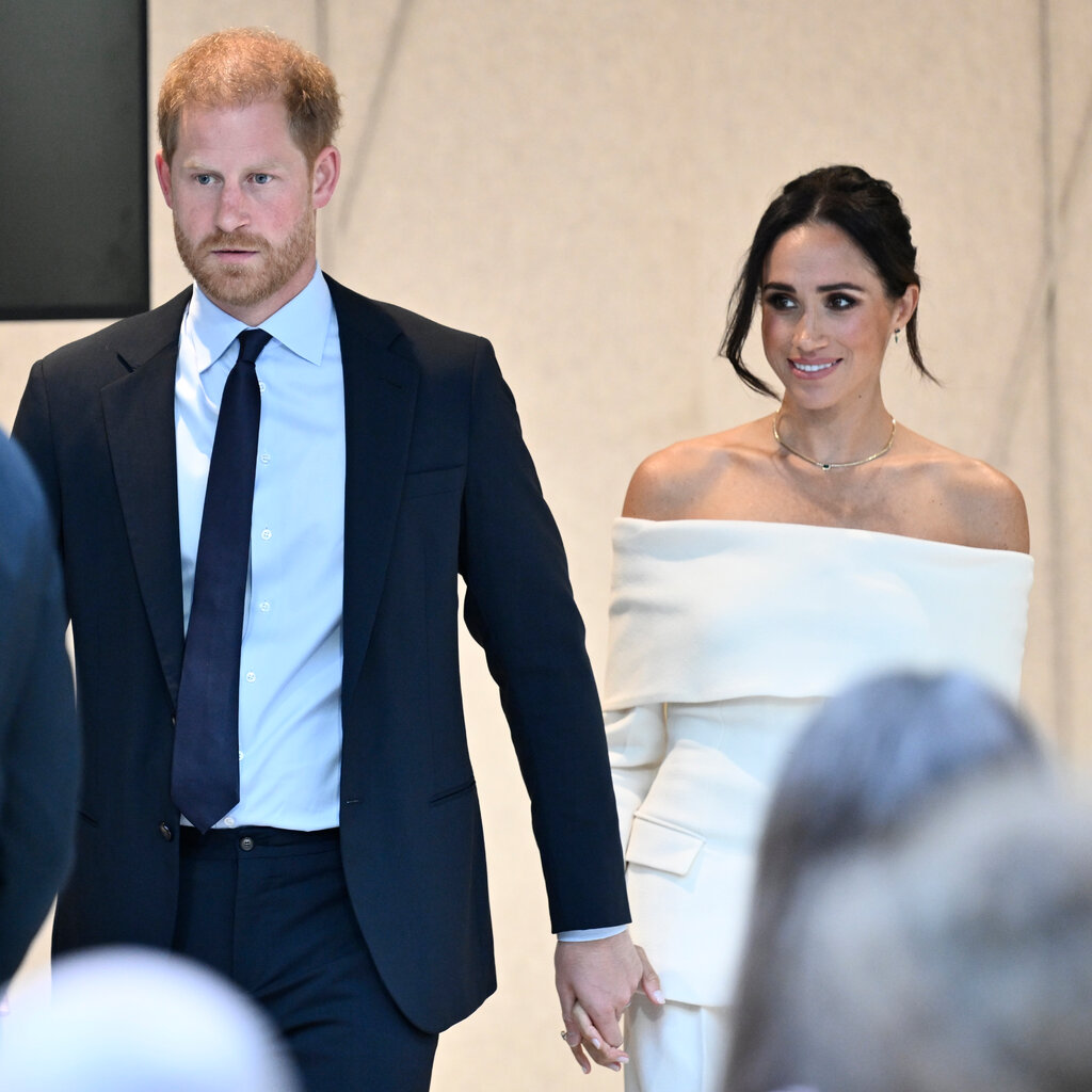 Prince Harry and Meghan, holding hands.