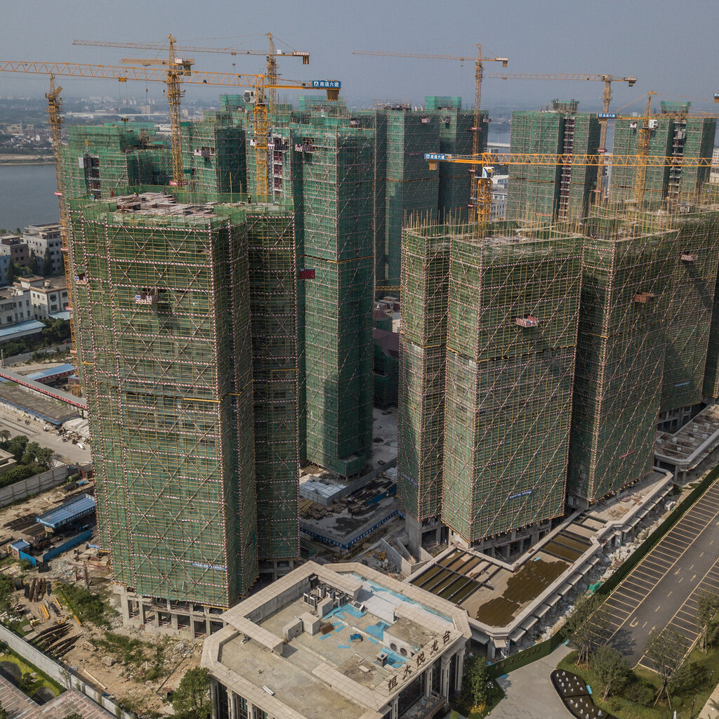 High-rise buildings under construction with scaffolding and cranes. 