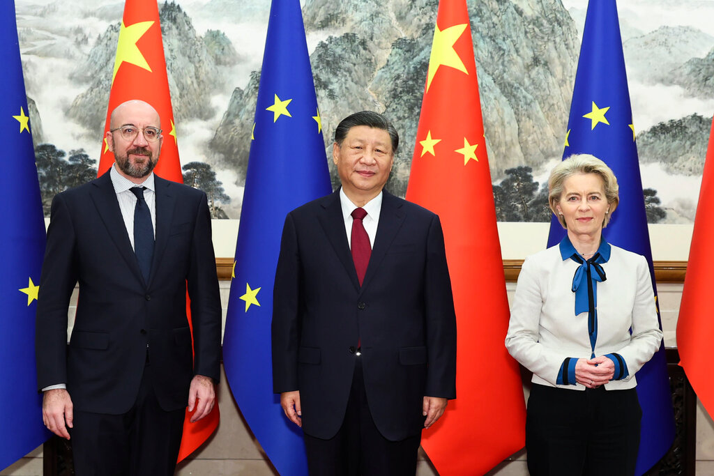 Charles Michel, Xi Jinping and Ursula von der Leyen pose for a photo in front of a row of European Union and Chinese flags.