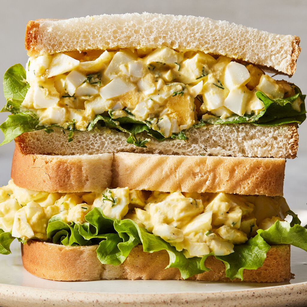 Two halves of an egg sandwich stacked on top of each other. 