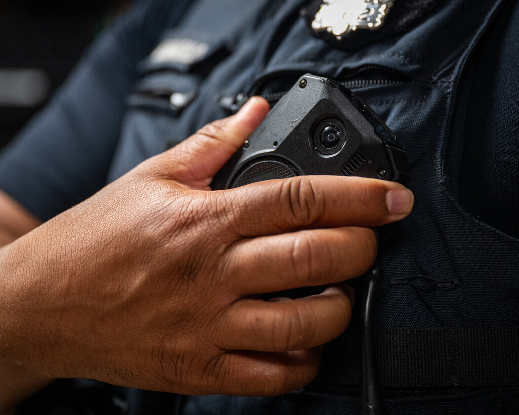 A close-up of a police officer’s chest and body camera.
