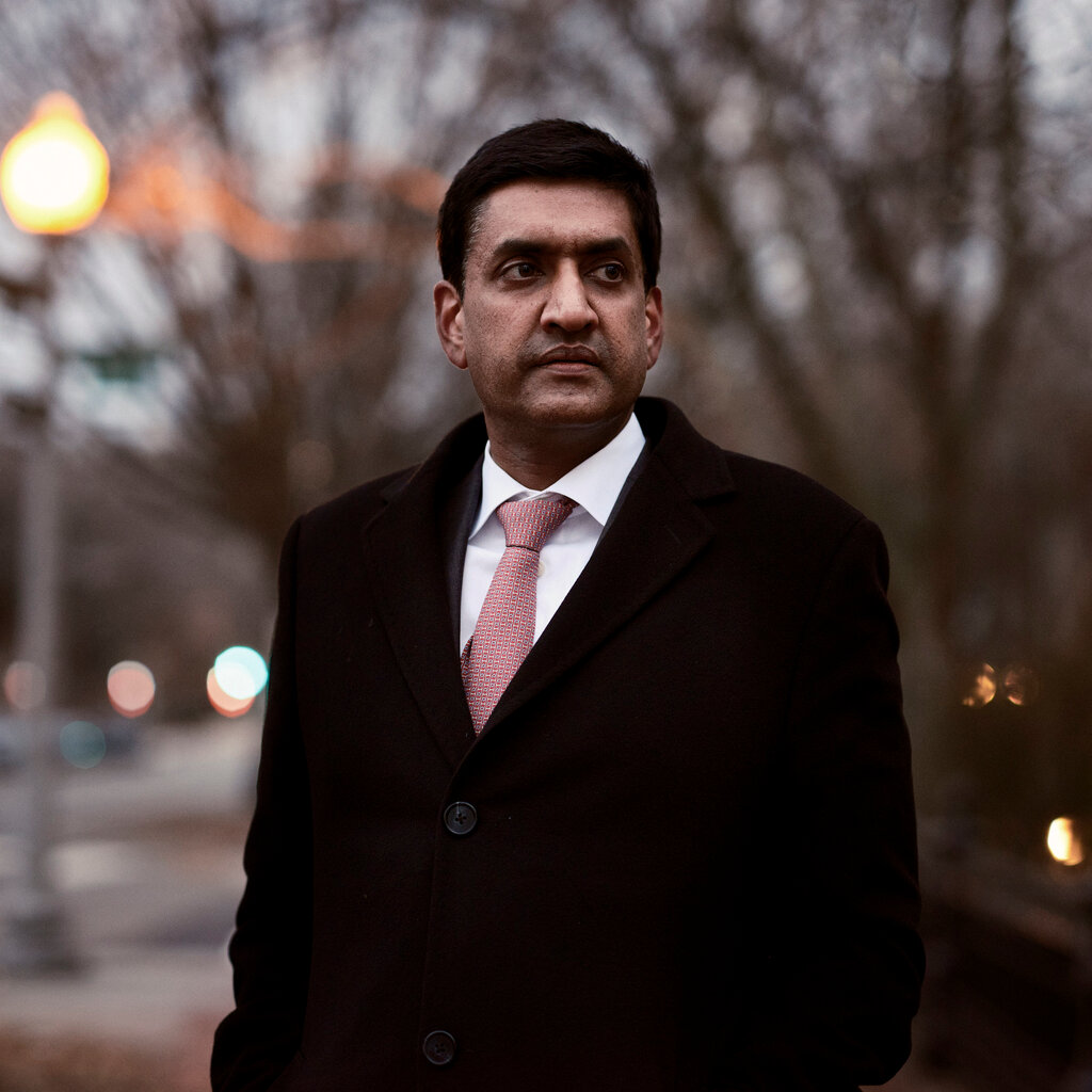 Ro Khanna standing for a portrait in a black coat with a red tie. 