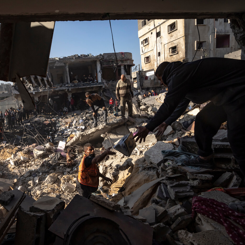 People search for bodies and survivors in the rubble of a residential building.