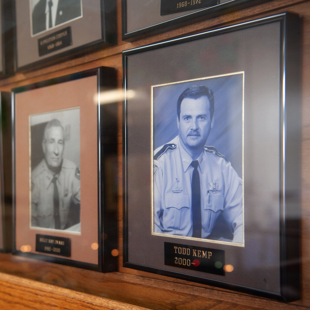 A framed photo of a man in uniform, with additional photos visible in the background.