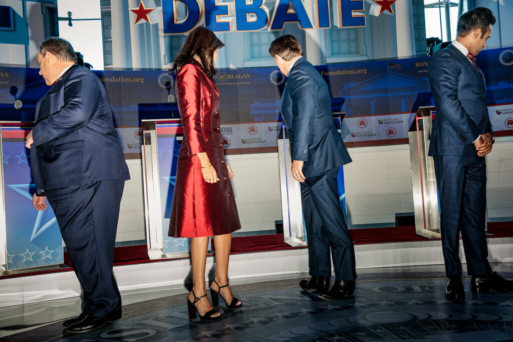 From left, Chris Christie, Nikki Haley, Ron DeSantis and Vivek Ramaswamy look away from the camera and toward their lecterns on a debate stage.