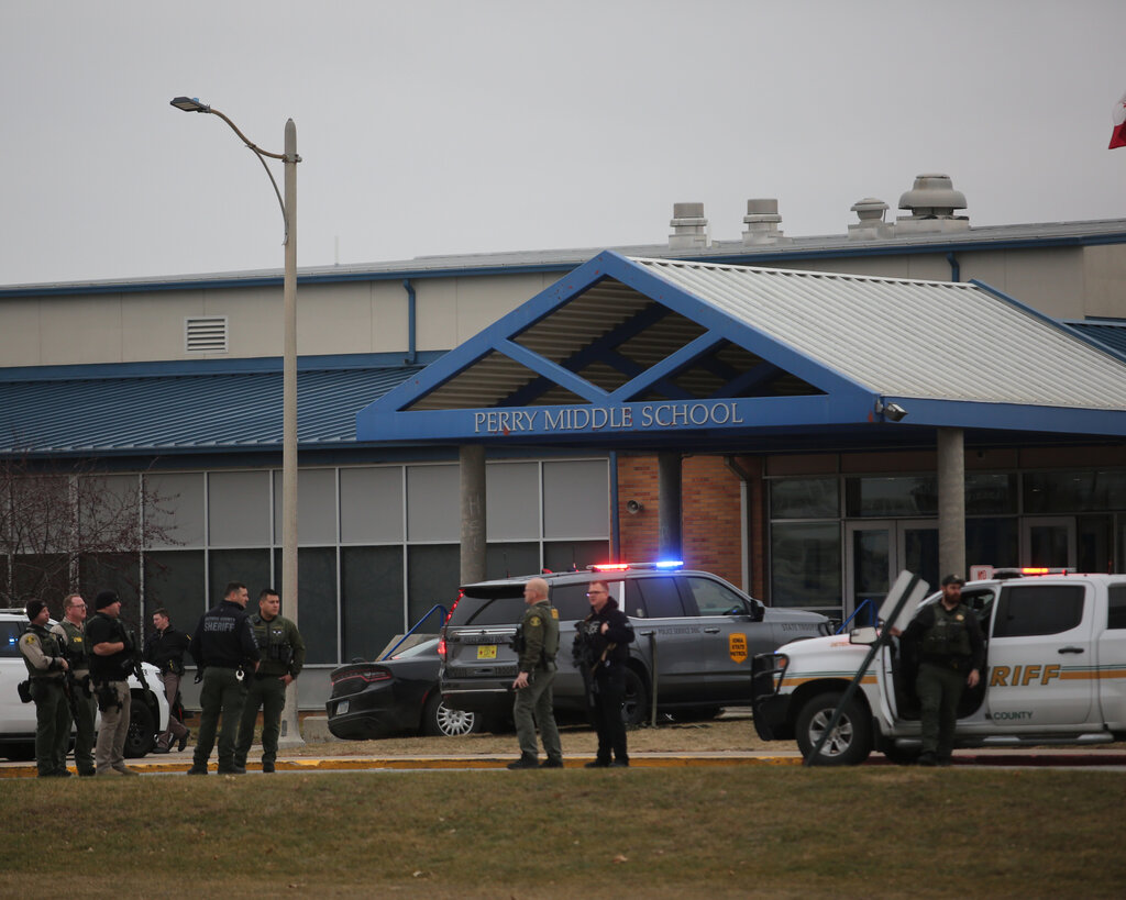 Police cars and officers standing outside Perry Middle School. 