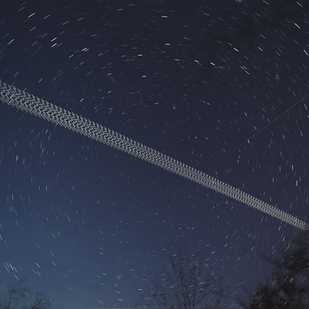 A streak of many many SpaceX satellites across the night sky.