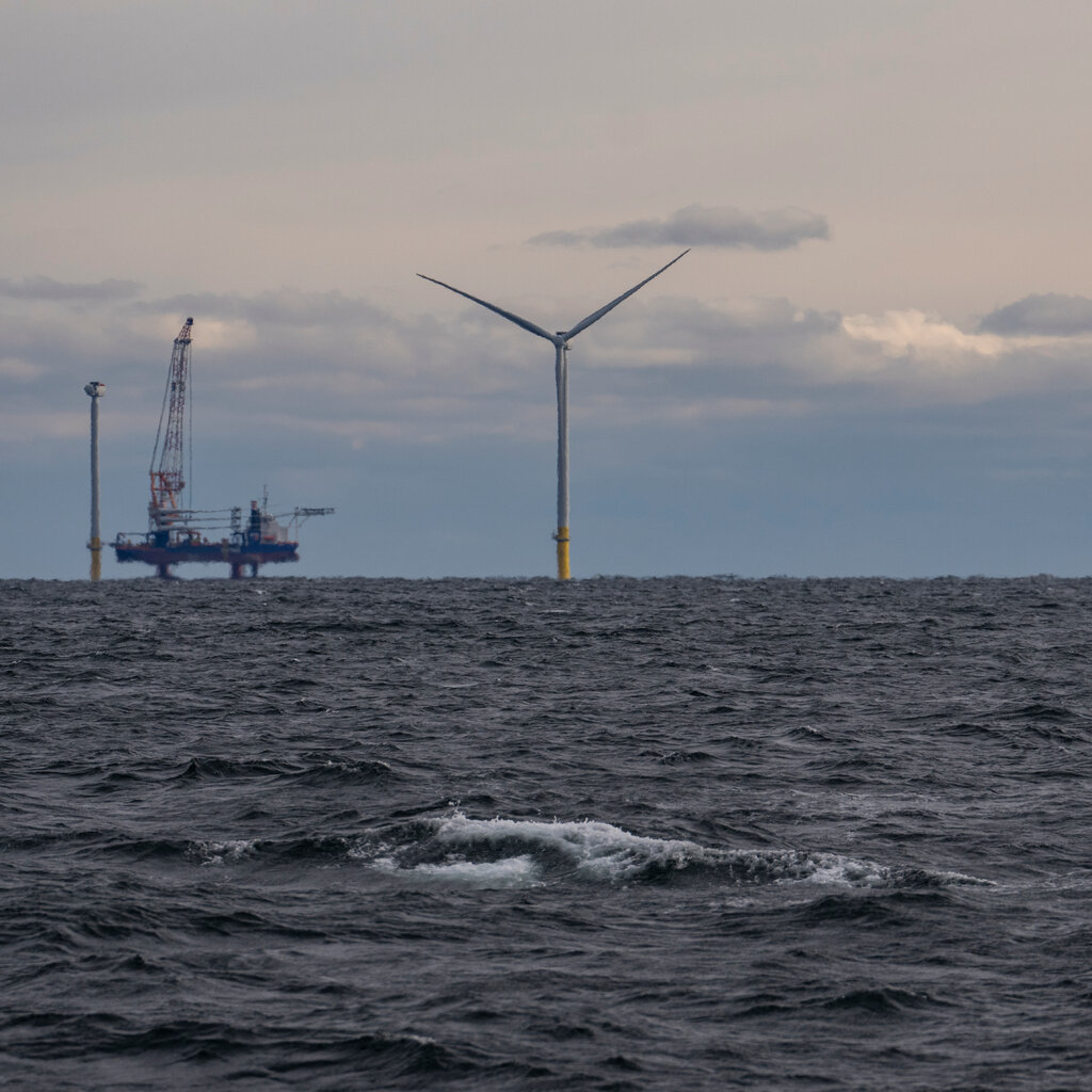 A single wind turbine in the ocean. 