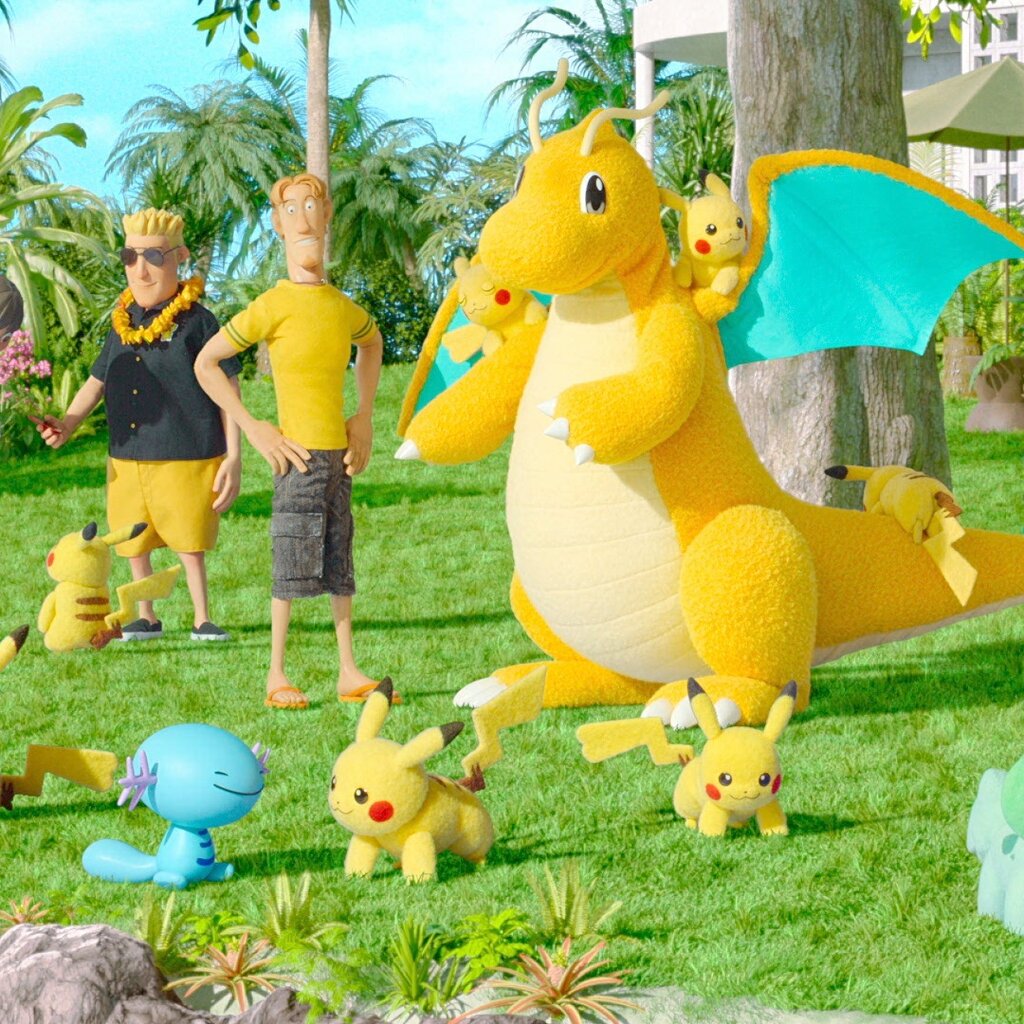 Pokémon and cartoon people mingle on green grass in a still frame from an animation.