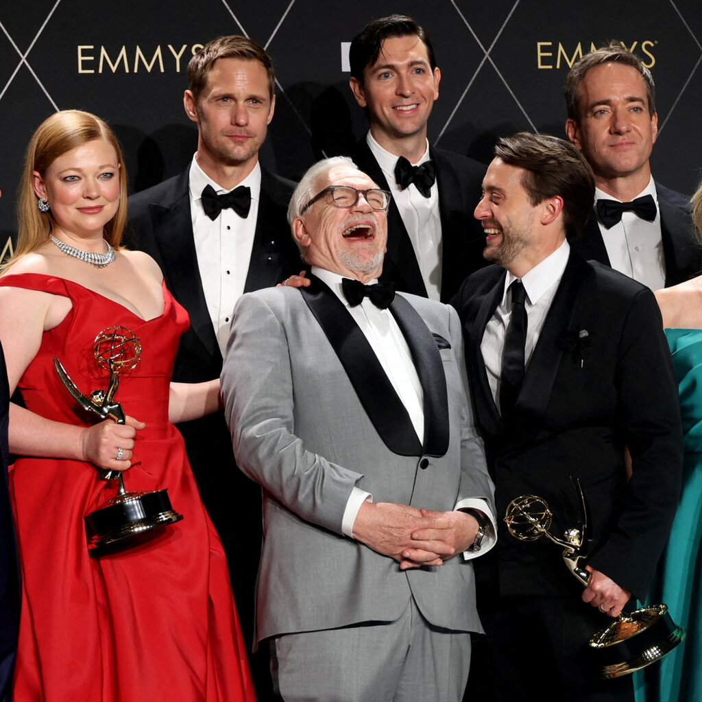The cast of “Succession” in formal attire as they pose with trophies.