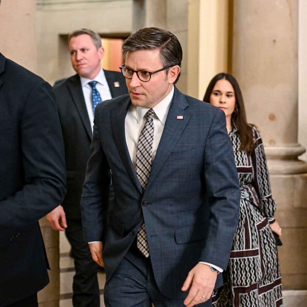 Speaker Mike Johnson, in a suit and tie, walking in the U.S. capitol.