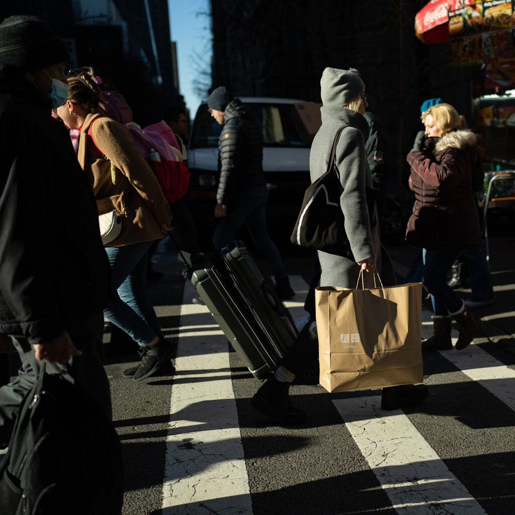 People walking in Manhattan. Dark shadows create a moody atmosphere.