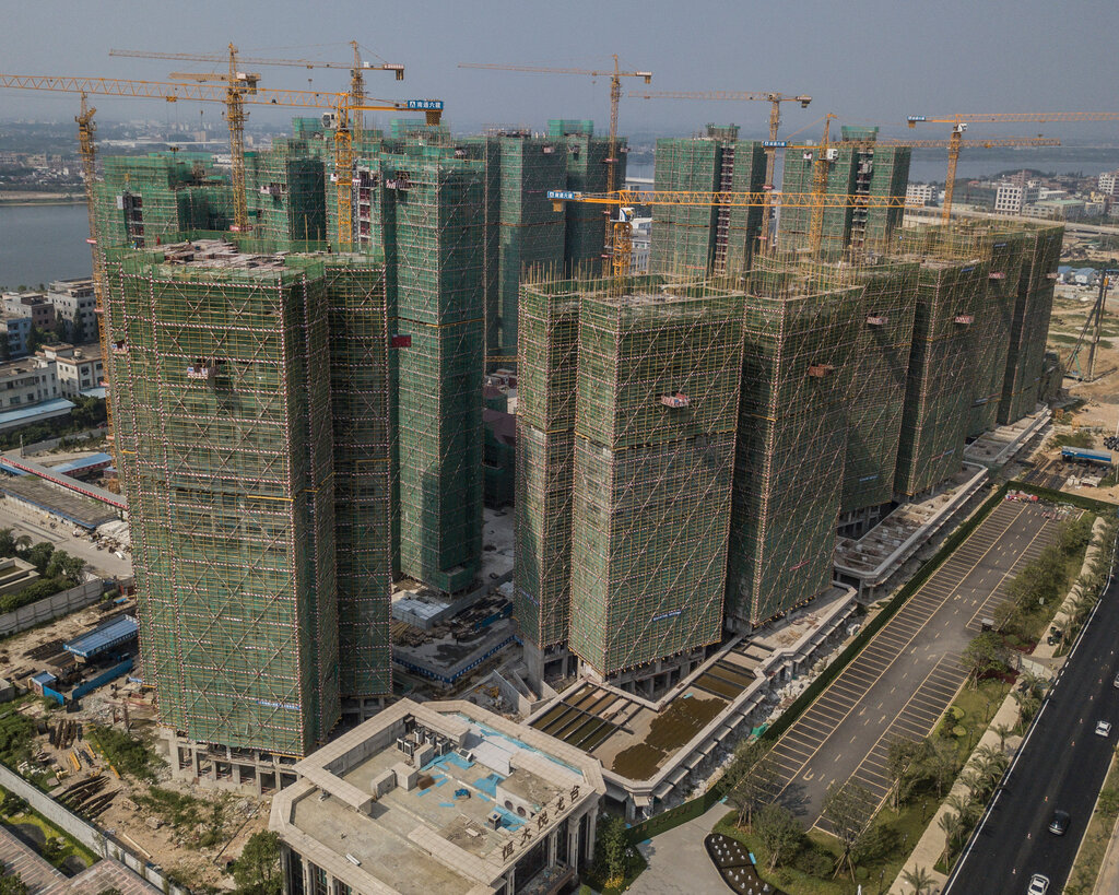 A group of buildings, with scaffolding and cranes on top of them. 