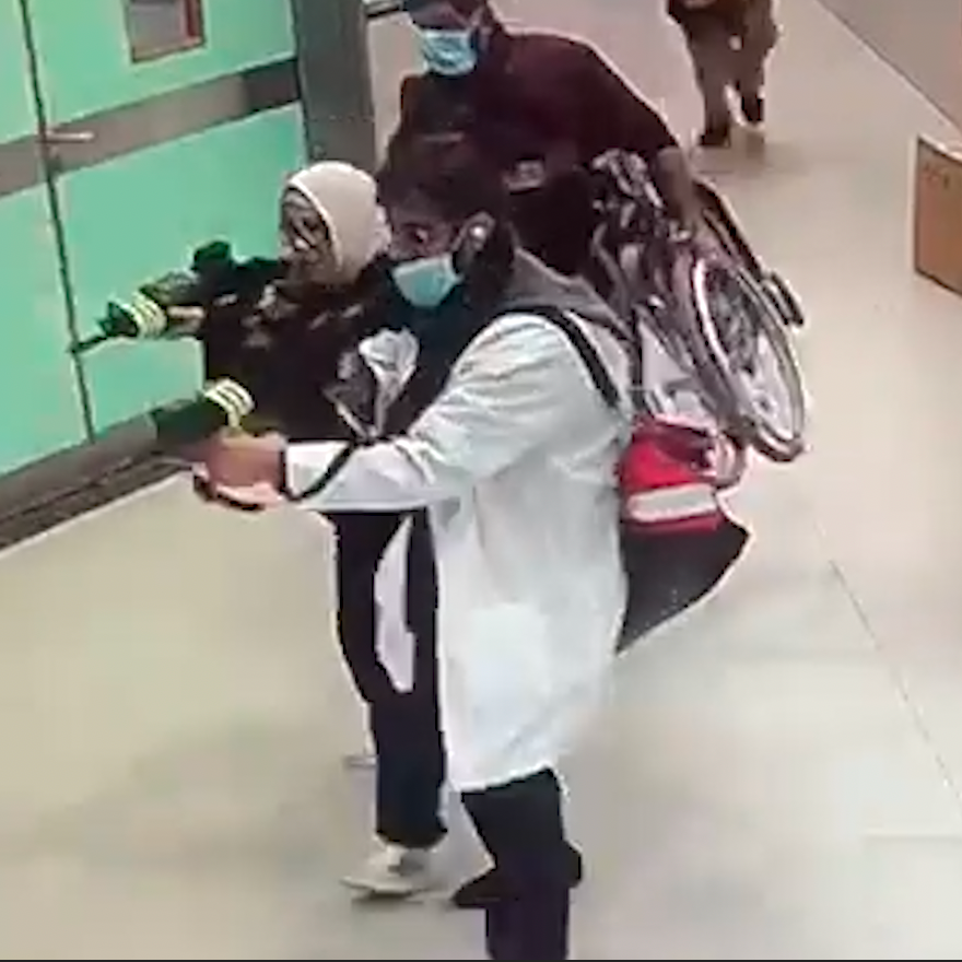 A screen capture of people pointing guns in a hospital. 