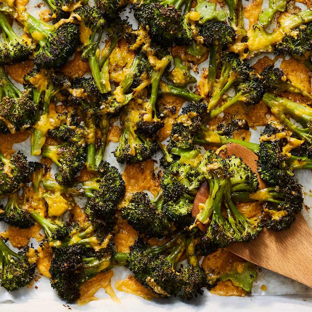 An overhead photo of roasted broccoli florets with melted cheese.