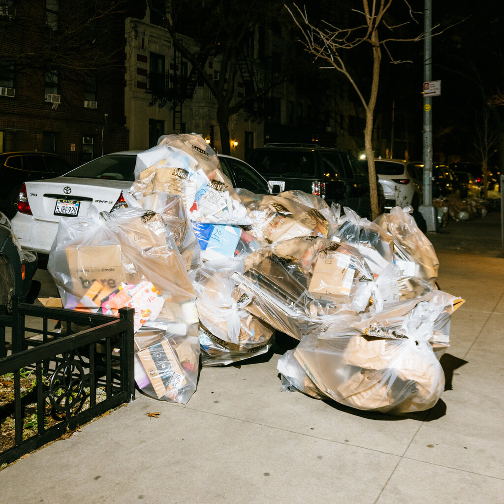Trash in clear bin bags on a sidewalk in New York City. 