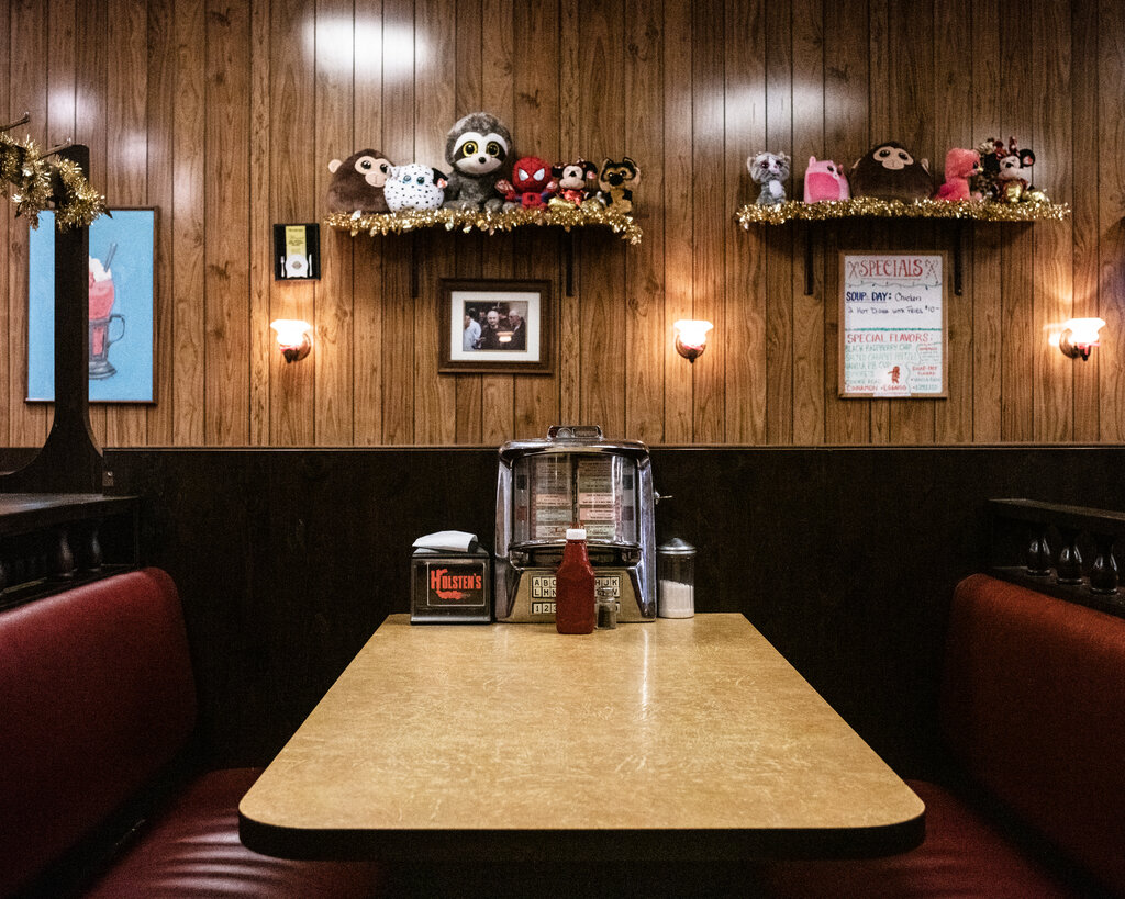 An empty diner booth with a tabletop jukebox.