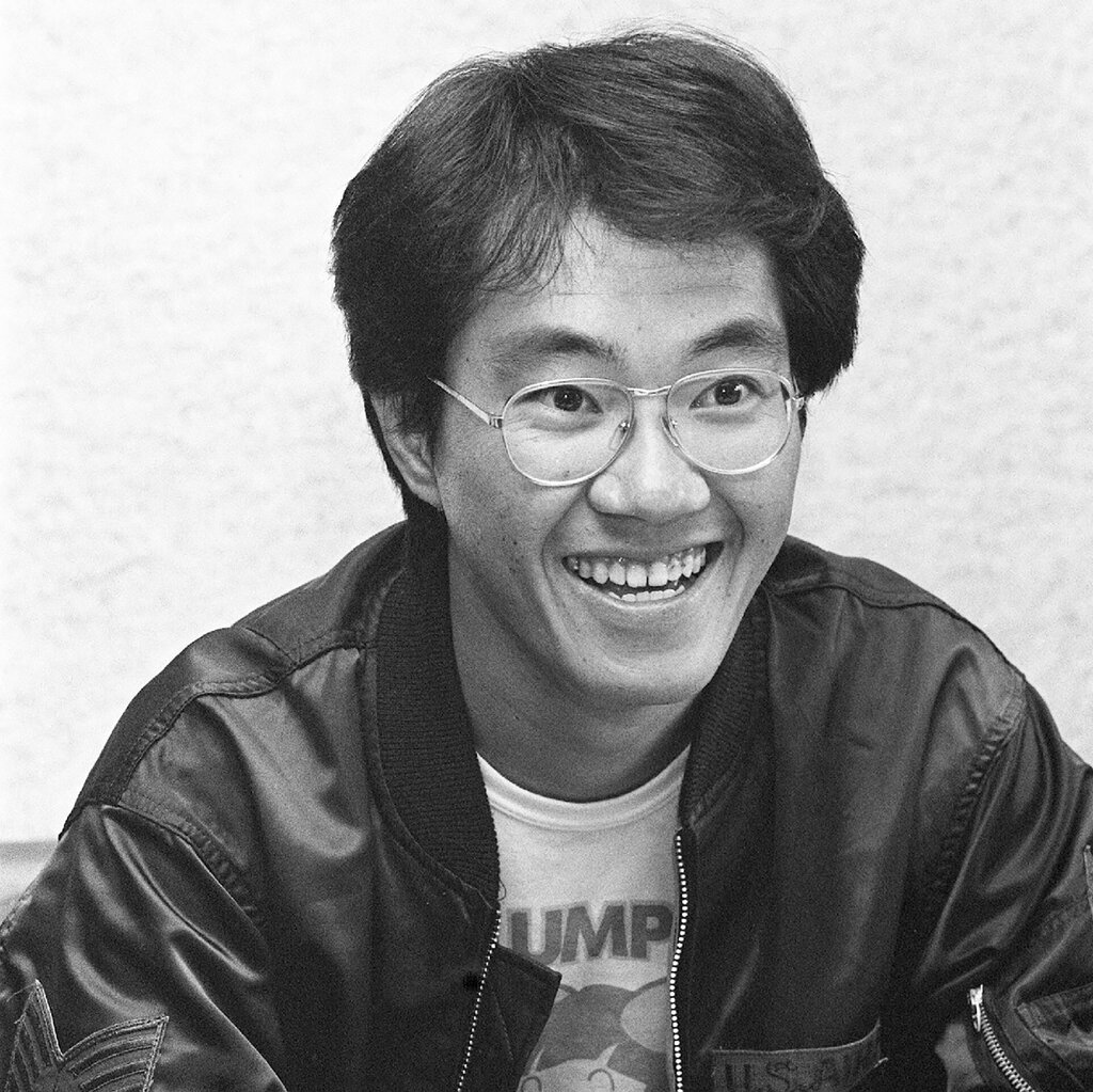 A smiling young man with glasses, a bomber jacket and a T-shirt.