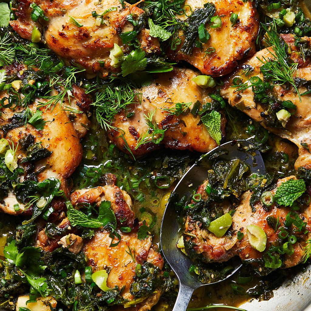 Burnished chicken thighs sit in a skillet, covered in a green, herby sauce.