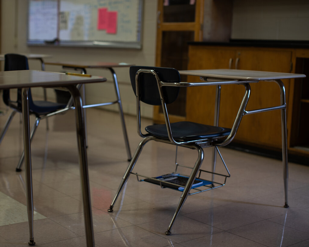 Empty seats and desks in a classroom.