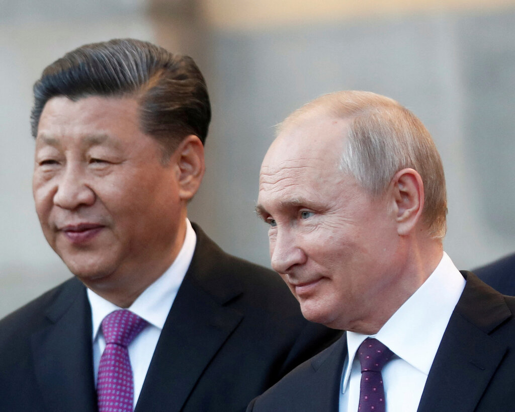 A head-and-shoulders photo of China’s president, Xi Jinping, left, and Russia’s president, Vladimir Putin. The two men are smiling and wearing suits. 